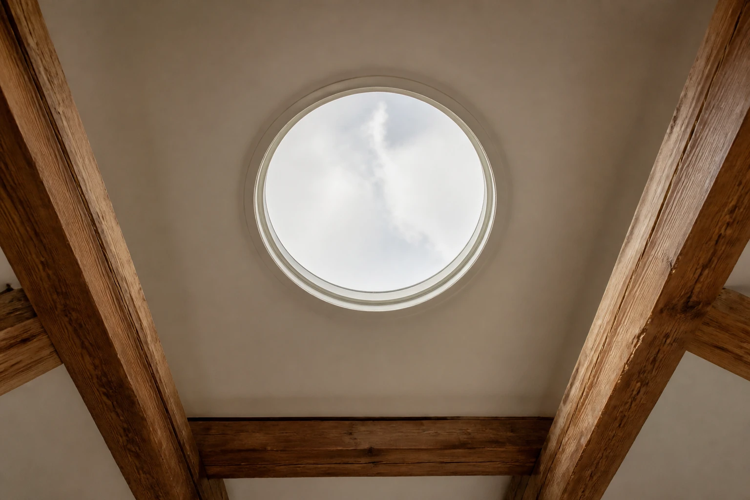 Puits de lumière tubulaire installé dans une toiture en tuiles, vue depuis l'intérieur d'une pièce rénovée